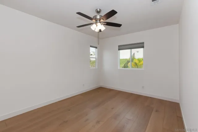 an empty room with a window and a ceiling fan