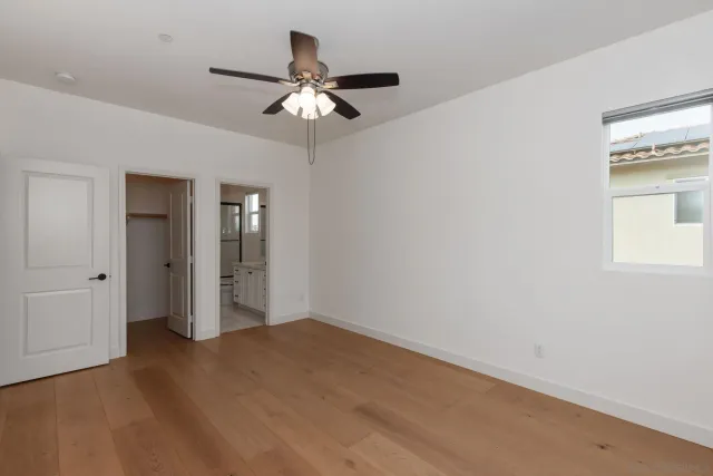 a view of an empty room with a chandelier fan