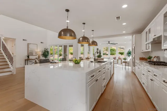 a kitchen with stainless steel appliances kitchen island granite countertop a stove and a large window