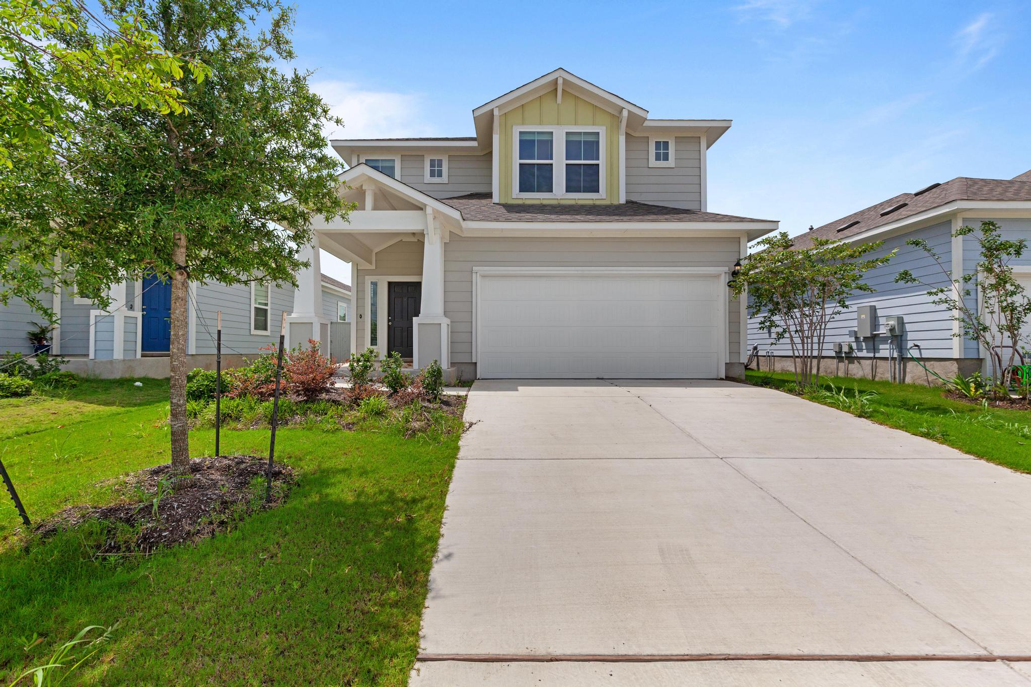242 Barley Lane Elgin, TX 78621 - Photo 1 of 31 Contemporary two-story residence featuring light gray siding and a prominent two-car garage