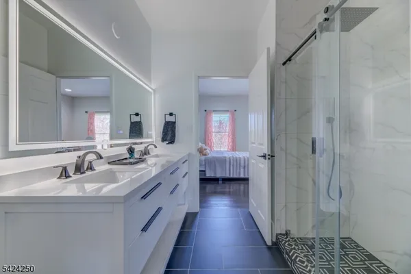 a en suite bathroom with a double vanity sink a mirror and a shower