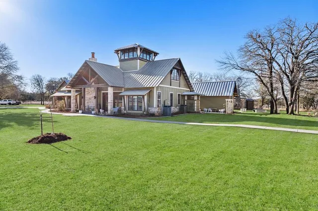 a front view of a house with a garden and trees