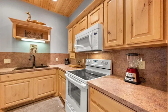 a bathroom with a granite countertop sink and a bathtub