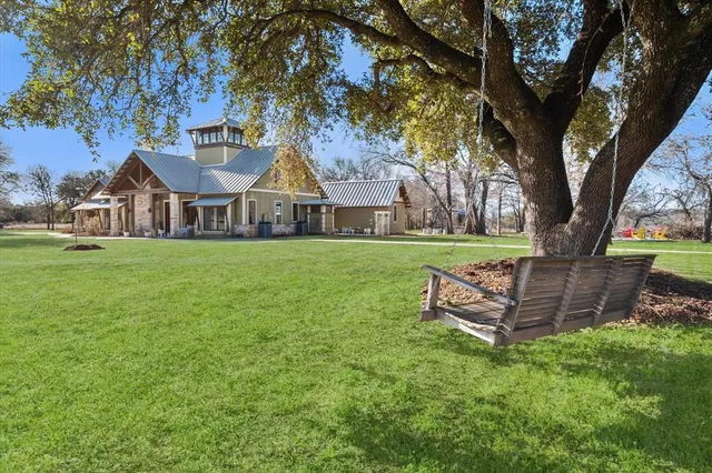 a front view of a house with a garden and trees