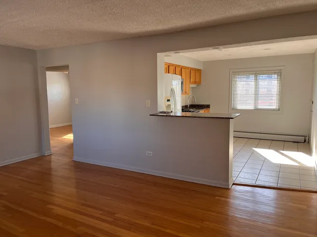 a view of a kitchen with wooden floor and a window