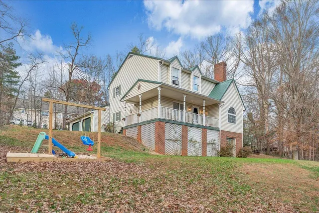 a view of a house with a yard and wooden fence