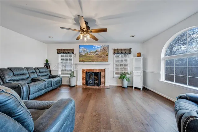 a living room with furniture a fireplace and a large window
