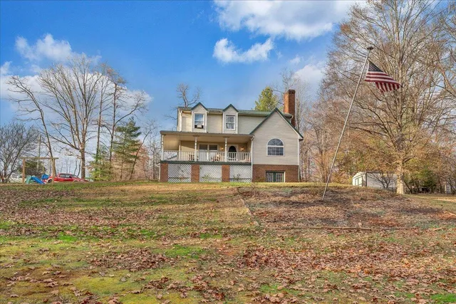 a view of a large house with a big yard and large tree