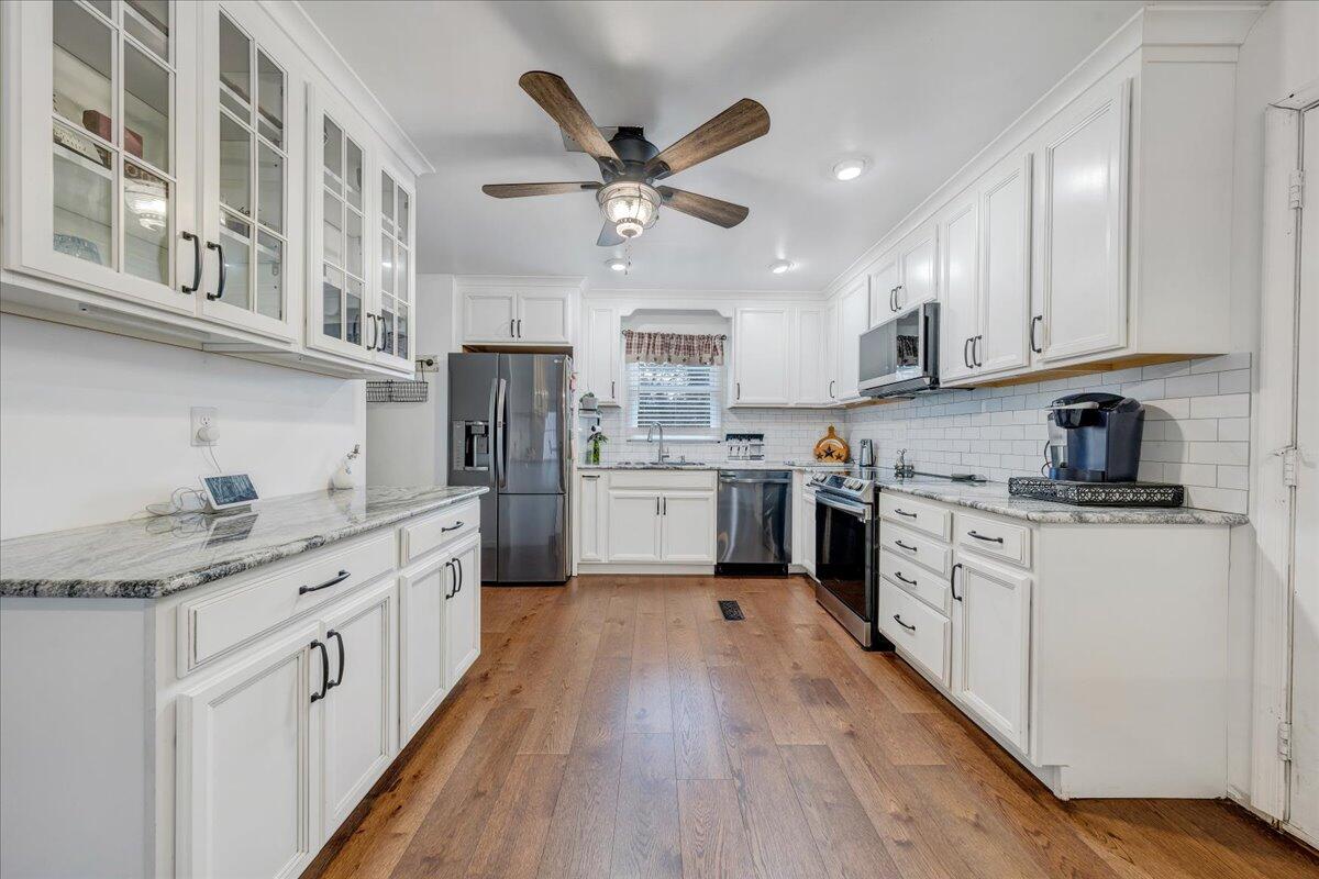 65 Avon Street Rocky Mount, VA 24151 - Photo 8 of 46 a kitchen with stainless steel appliances granite countertop a sink cabinets and wooden floor