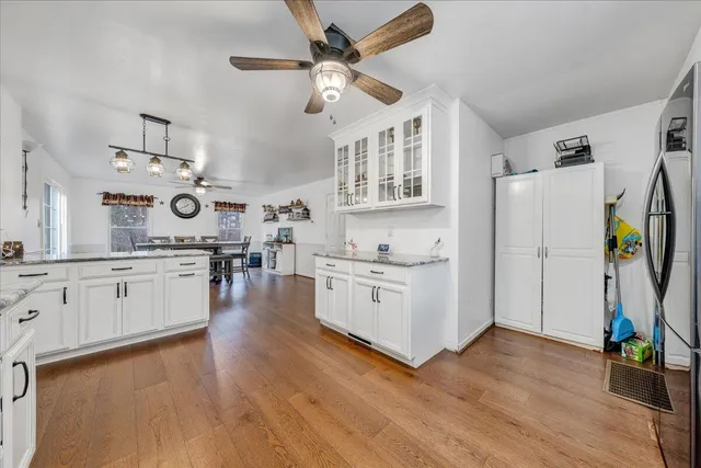 a kitchen with stainless steel appliances white cabinets and wooden floor
