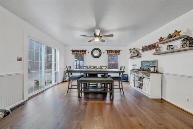 a living room with stainless steel appliances granite countertop furniture wooden floor and a fireplace