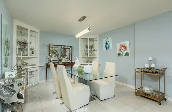 a kitchen with stainless steel appliances a table and chairs in it