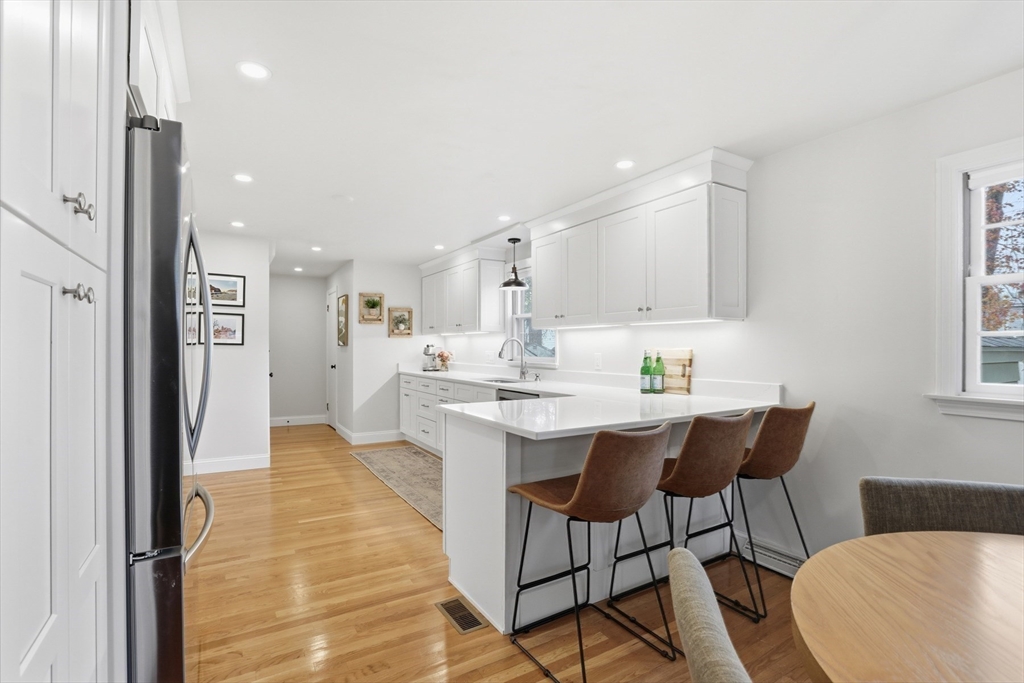 5 Sheffield Road Stoneham, MA 02180 - Photo 18 of 37 a kitchen with stainless steel appliances kitchen island granite countertop a sink and a refrigerator