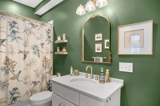 a bathroom with a sink mirror and toilet