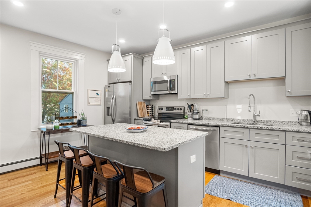 149 High Street, Unit 4 Danvers, MA 01923 - Photo 5 of 33 a kitchen with a table chairs sink and cabinets