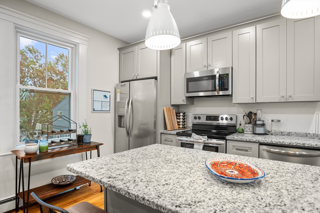 149 High Street, Unit 4 Danvers, MA 01923 - Photo 8 of 33 a kitchen with stainless steel appliances granite countertop a stove refrigerator sink and cabinets