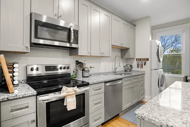 a kitchen with stainless steel appliances granite countertop a sink a stove a microwave and cabinets