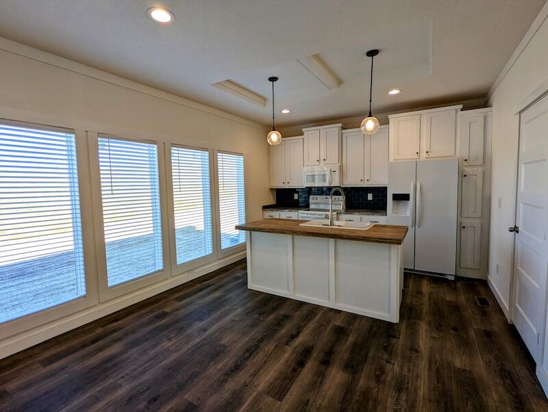 129 Long Level Road Southwest Floyd, VA 24091 - Photo 6 of 25 a kitchen with kitchen island granite countertop a stove a sink and white cabinets