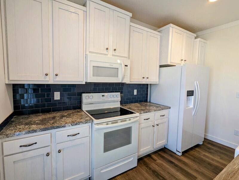 129 Long Level Road Southwest Floyd, VA 24091 - Photo 7 of 25 a kitchen with granite countertop white cabinets and white appliances