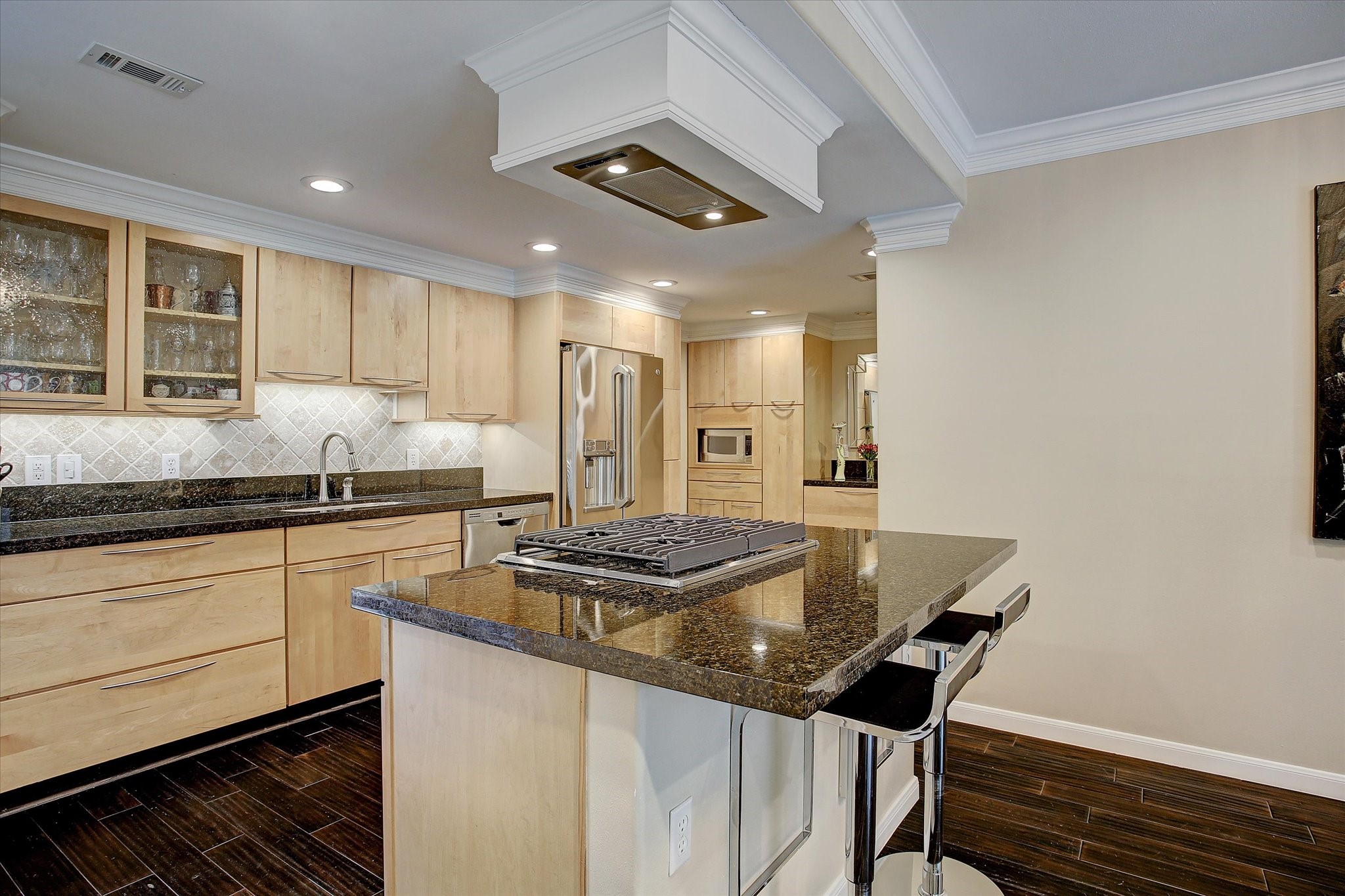 2003 Chilton Road Houston, TX 77019 - Photo 4 of 17 This is a huge kitchen featuring light wood cabinetry, granite countertops, stainless steel appliances, and a large center island with gas cooktop and breakfast bar seating. Recessed lighting, crown molding, and glass-front cabinetry add a polished touch to the open, functional design. So much storage here plus a walk-in pantry.