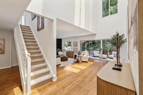 a view of a living room with furniture and floor to ceiling window