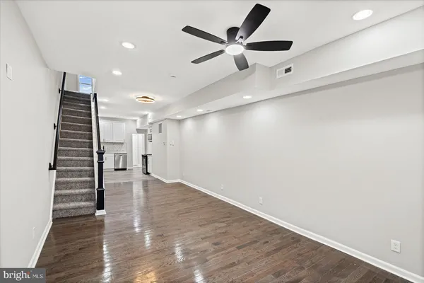a view of staircase with wooden floor and white walls