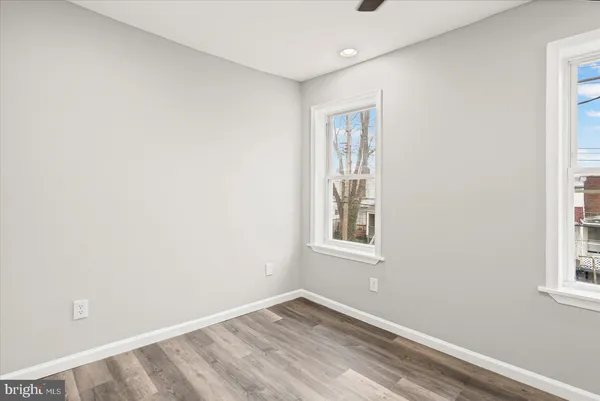 an empty room with windows and fan