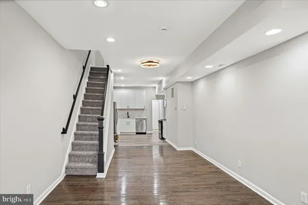 a kitchen with stainless steel appliances white cabinets a sink a stove a refrigerator and white cabinets