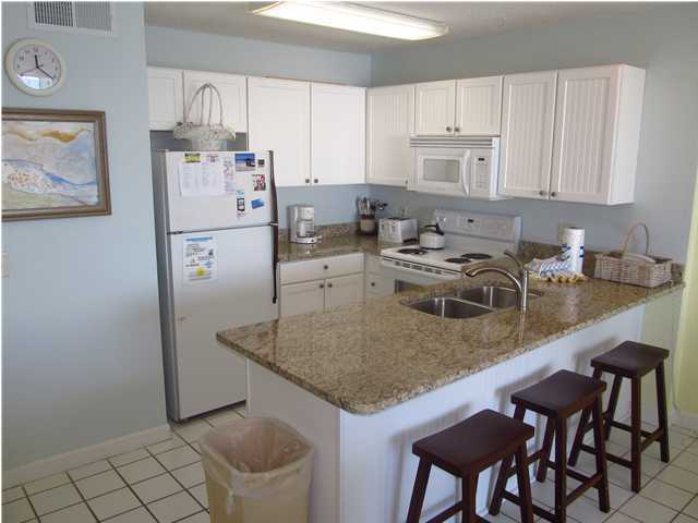 8294 Hwy Inlet Beach, Unit 9 30A Inlet Beach, FL 32461 - Photo 3 of 10 a kitchen with stainless steel appliances granite countertop a sink a microwave a refrigerator and white cabinets