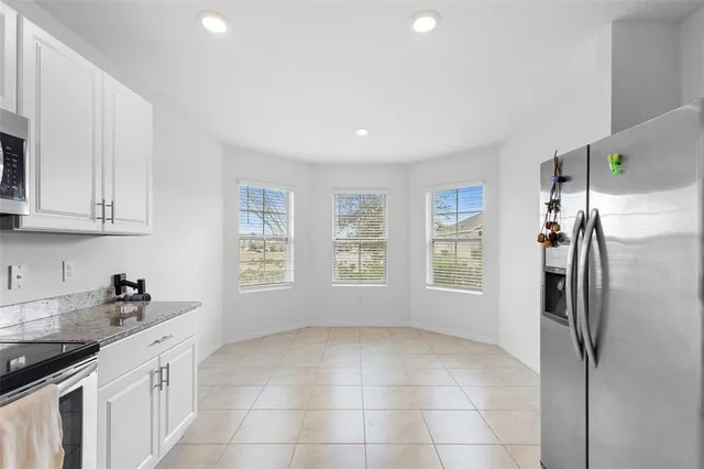 a kitchen with stainless steel appliances a refrigerator sink and white cabinets