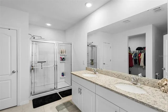 a bathroom with a granite countertop sink a toilet and shower