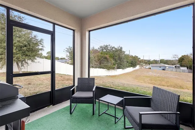 a living room with furniture and a floor to ceiling window