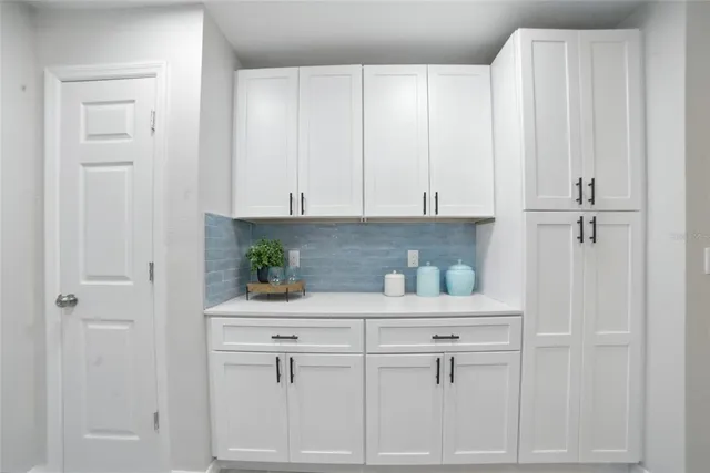 a kitchen with white cabinets and white appliances