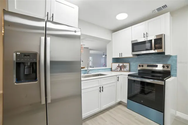 a kitchen with stainless steel appliances granite countertop a stove and a refrigerator