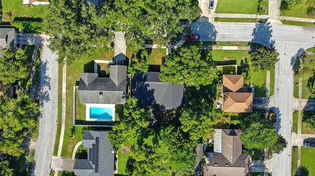 an aerial view of a residential houses with yard