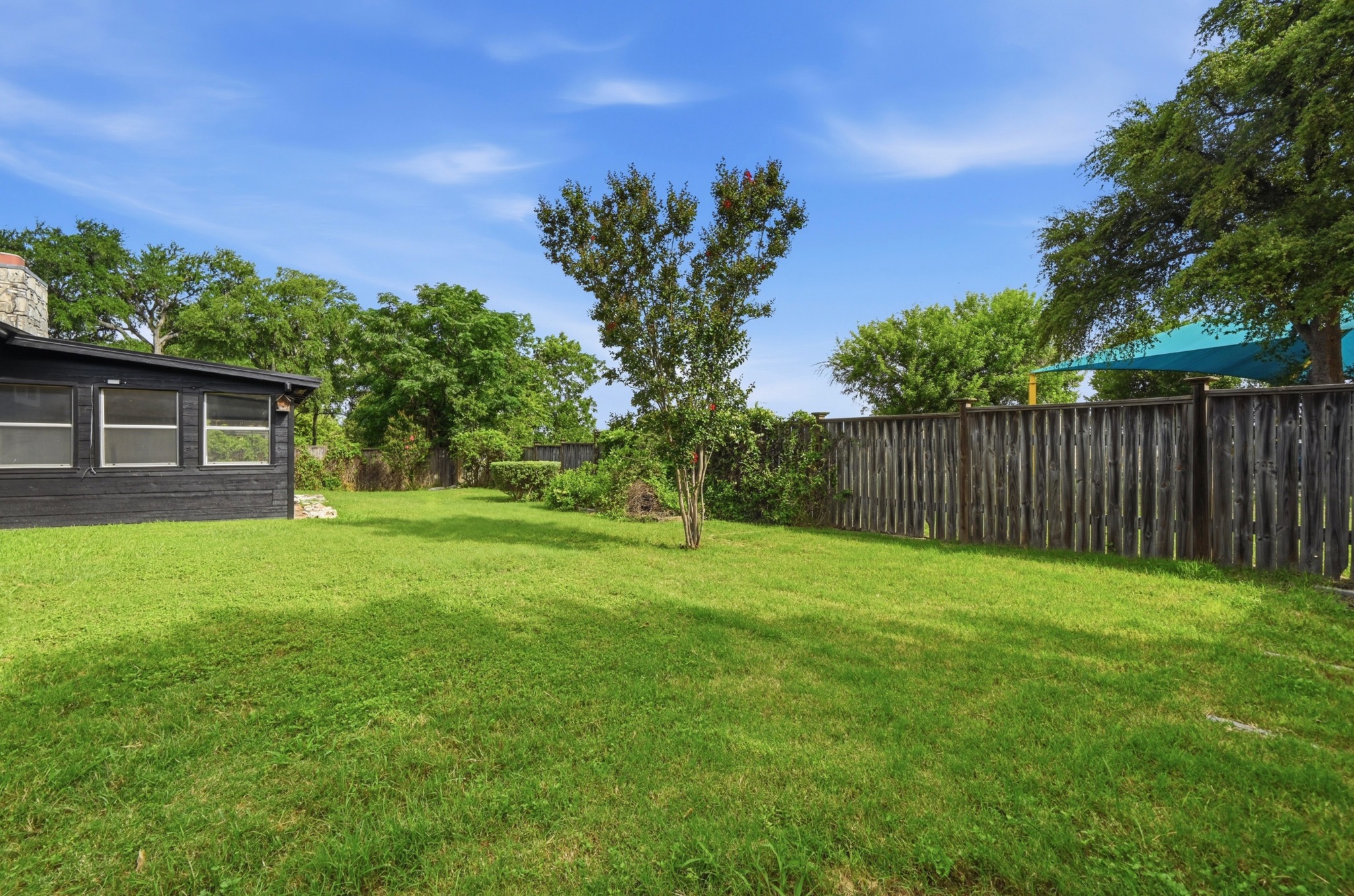 10504 Hard Rock Road Austin, TX 78750 - Photo 26 of 28 A verdant lawn invites outdoor enjoyment, bordered by privacy fencing and mature shade trees.