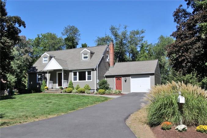 a front view of a house with a yard and potted plants