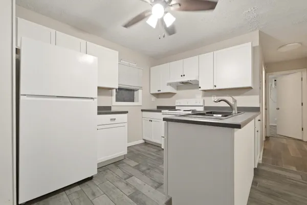 a kitchen with white cabinets and white appliances