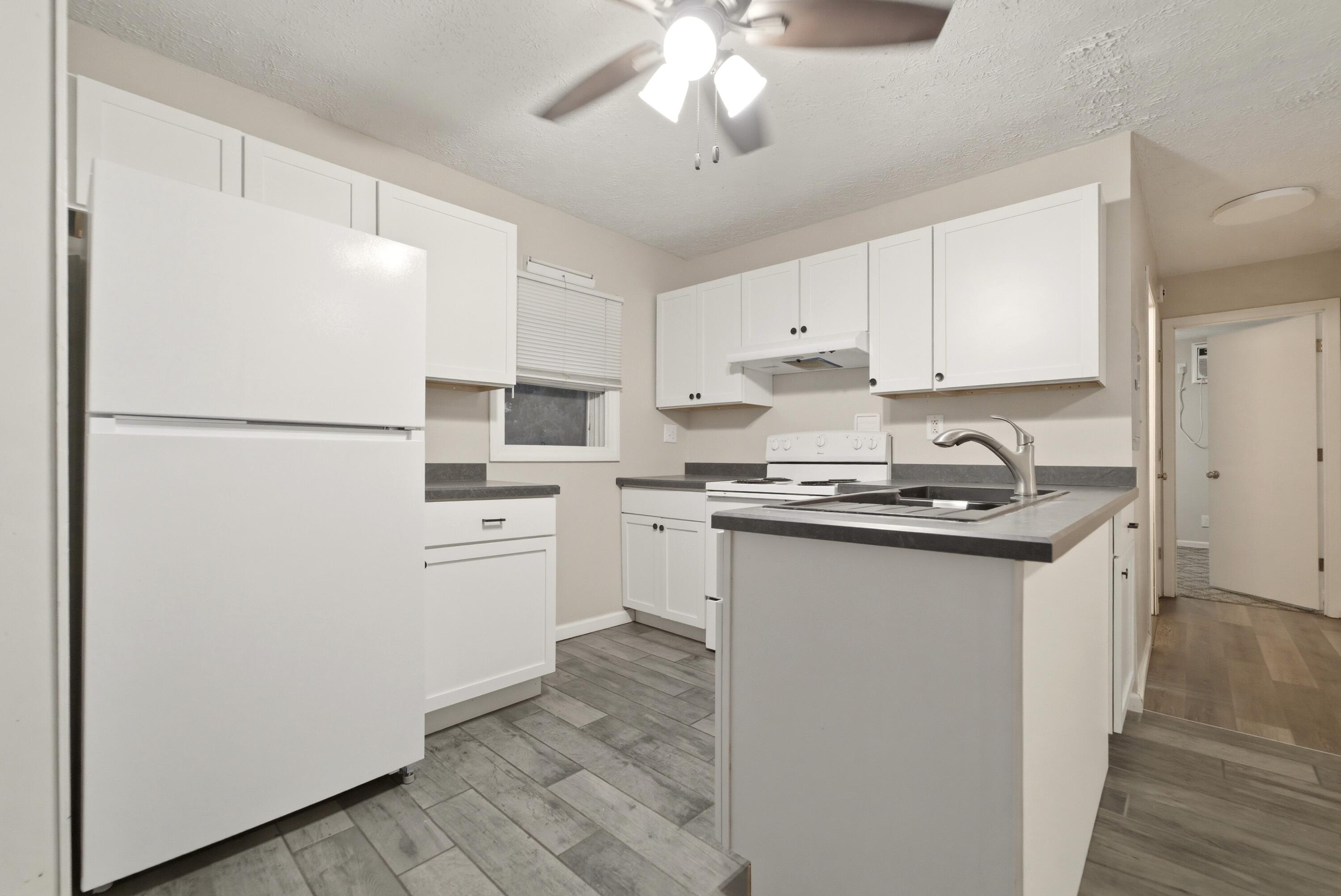 140 Sycamore Court, Unit 142 Hebron, IN 46341 - Photo 4 of 11 a kitchen with white cabinets and white appliances