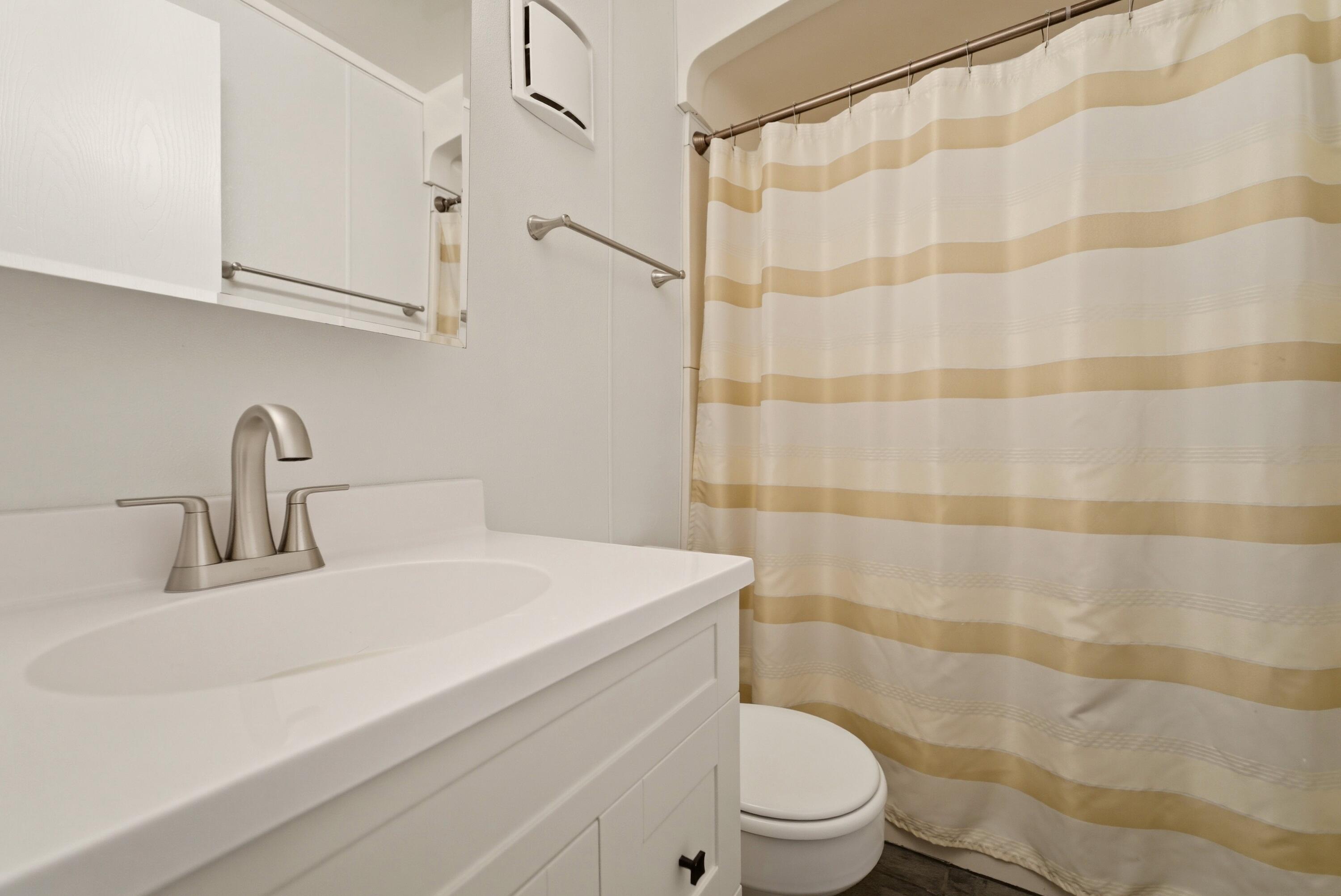 140 Sycamore Court, Unit 142 Hebron, IN 46341 - Photo 7 of 11 a bathroom with a sink a toilet and shower curtain