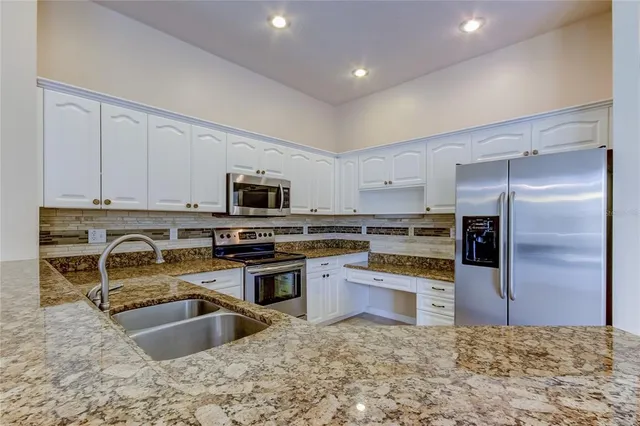 a kitchen with stainless steel appliances granite countertop a refrigerator and a stove
