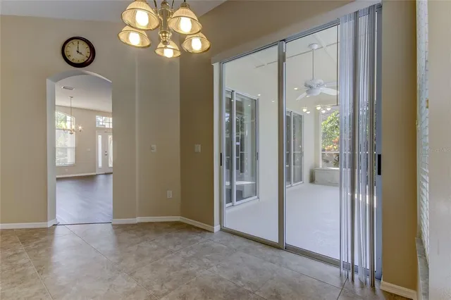 a view of a room with a window and a chandelier fan