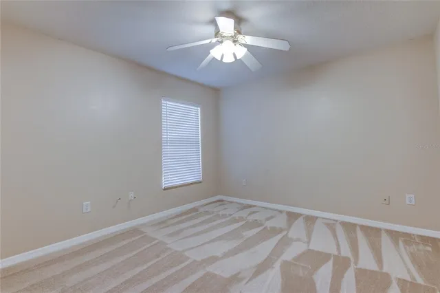 a view of a livingroom with a ceiling fan and window