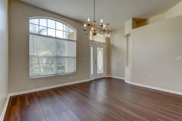 a view of a room with wooden floor and chandelier
