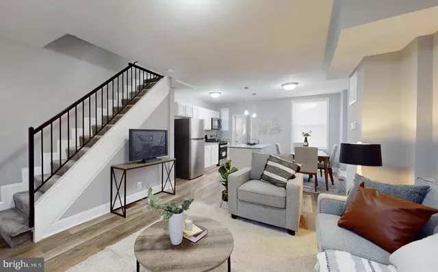 a living room with furniture kitchen view and a flat screen tv