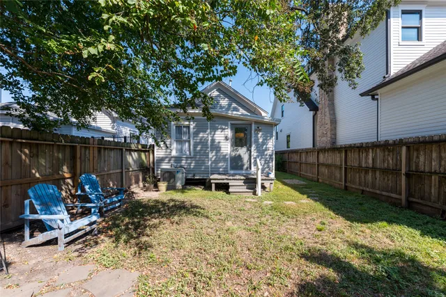 a view of a chair and table in backyard of the house