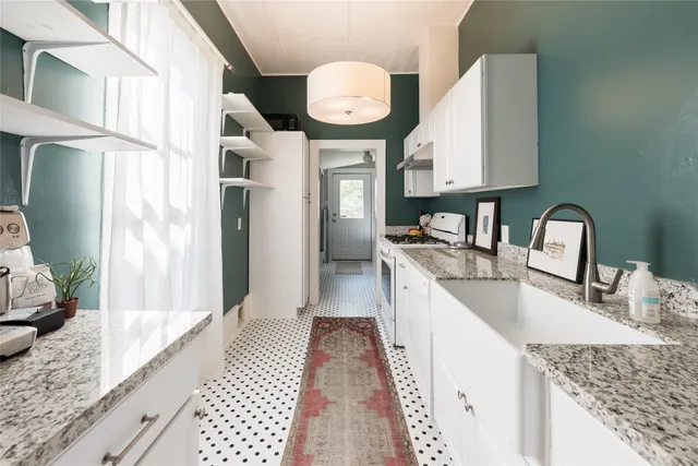 a kitchen with stainless steel appliances granite countertop a sink dishwasher a stove and a microwave oven with cabinets