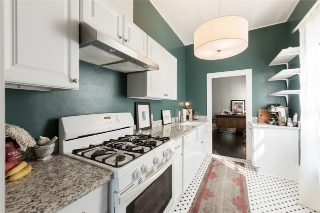 a kitchen with a stove and a chandelier