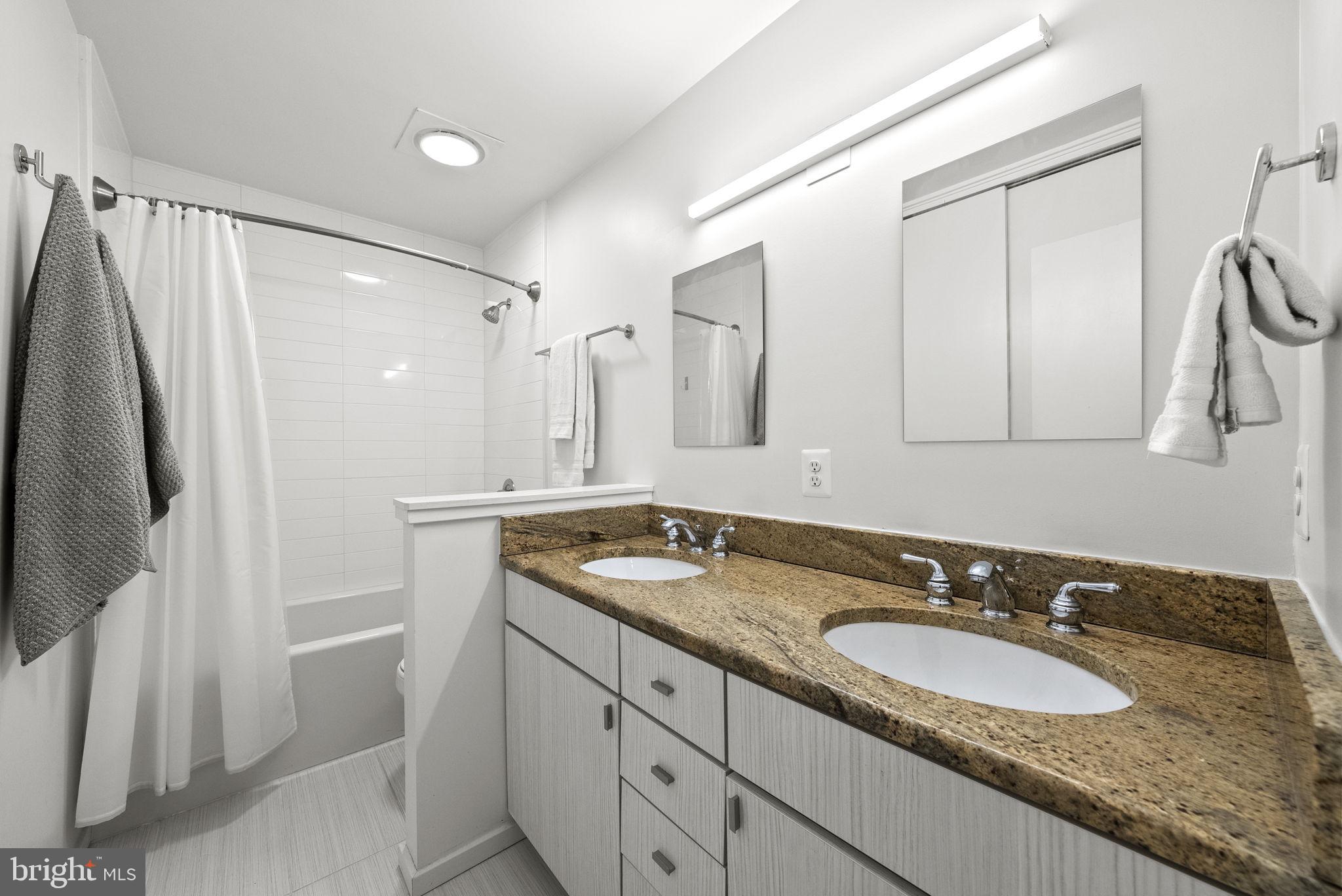 11585 Maple Ridge Road Reston, VA 20190 - Photo 25 of 48 a bathroom with a granite countertop double vanity sink and mirror