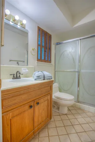 a bathroom with a granite countertop toilet sink and mirror